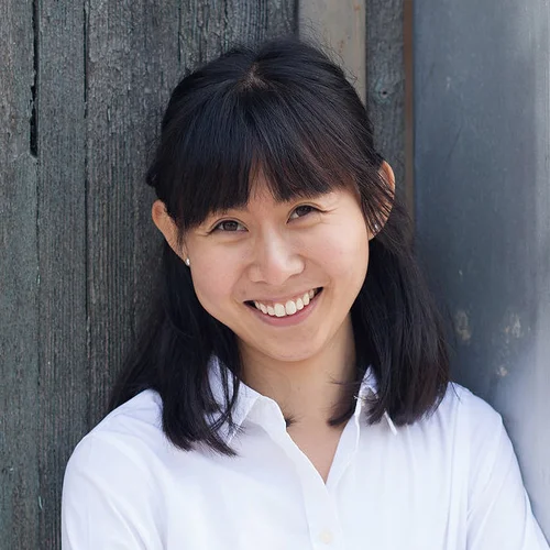 Dr. Yan Yen Loo Naturopathic doctor headshot against dark green-grey wooden panels cropped