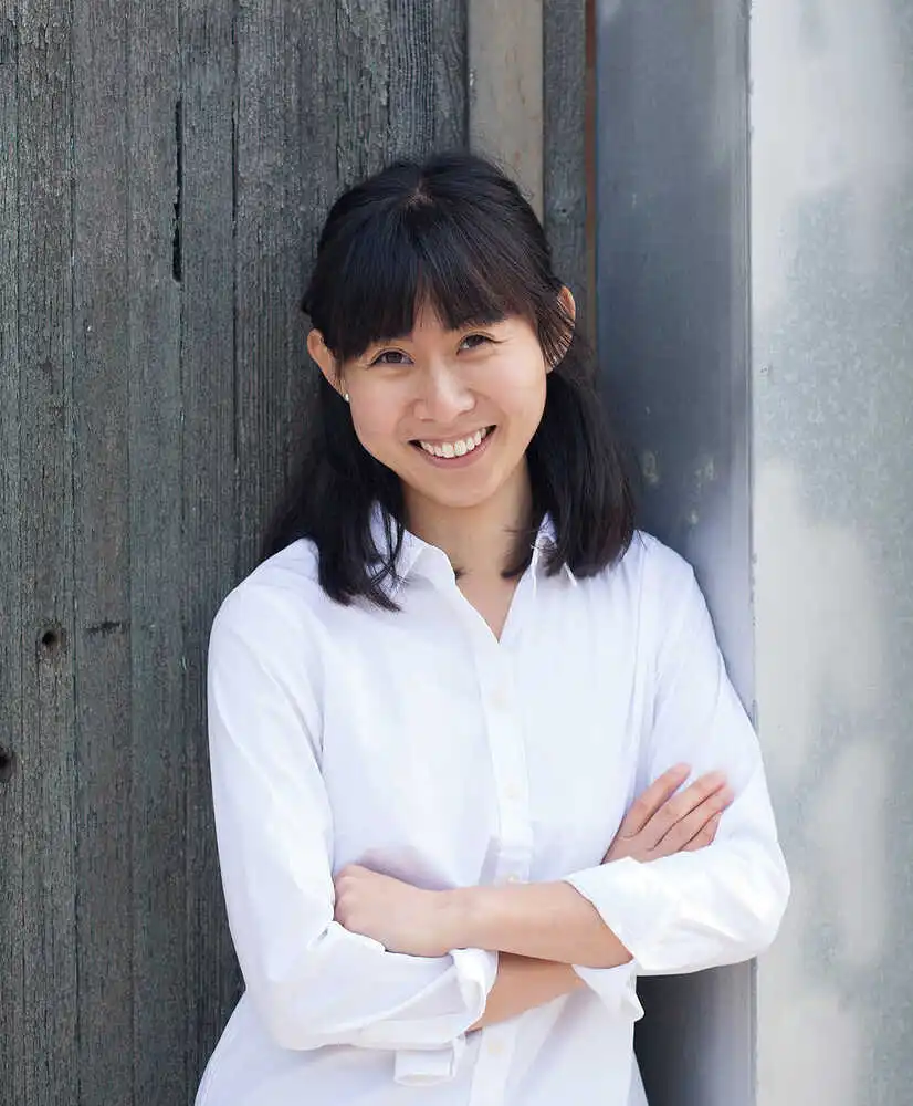 Dr. Yan Yen Loo Naturopathic doctor headshot against dark green-grey wooden panels