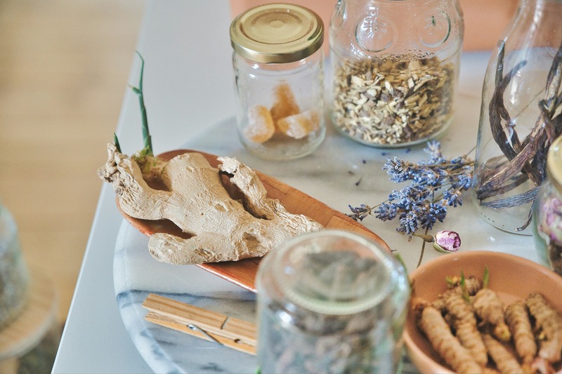 table with herbal ingredients in glass jars and bowl ginger turmeric ginseng root vitamin c for immune support