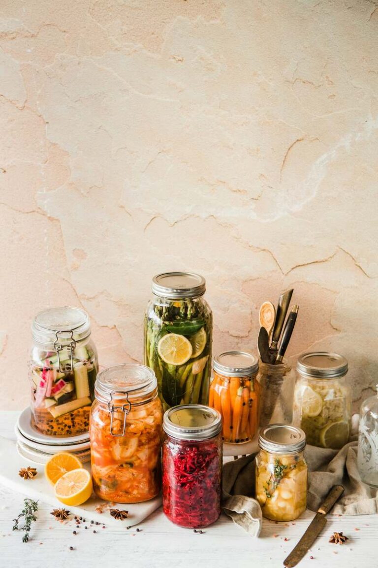 digestive health optimize gut microbiome blog header image with glass jars of fermented and prebiotic foods