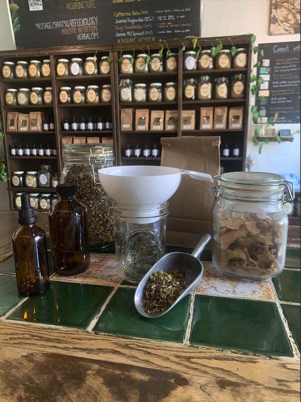 roncys apothecary herb shop and wellness clinic sustainability eco-friendly initiatives bring your own container and jars program for herbs and tincture with shelving in the background